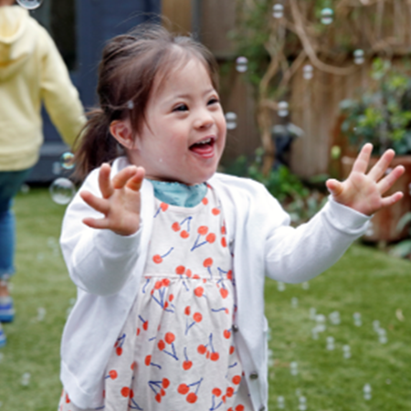 little girl playing in bubbles